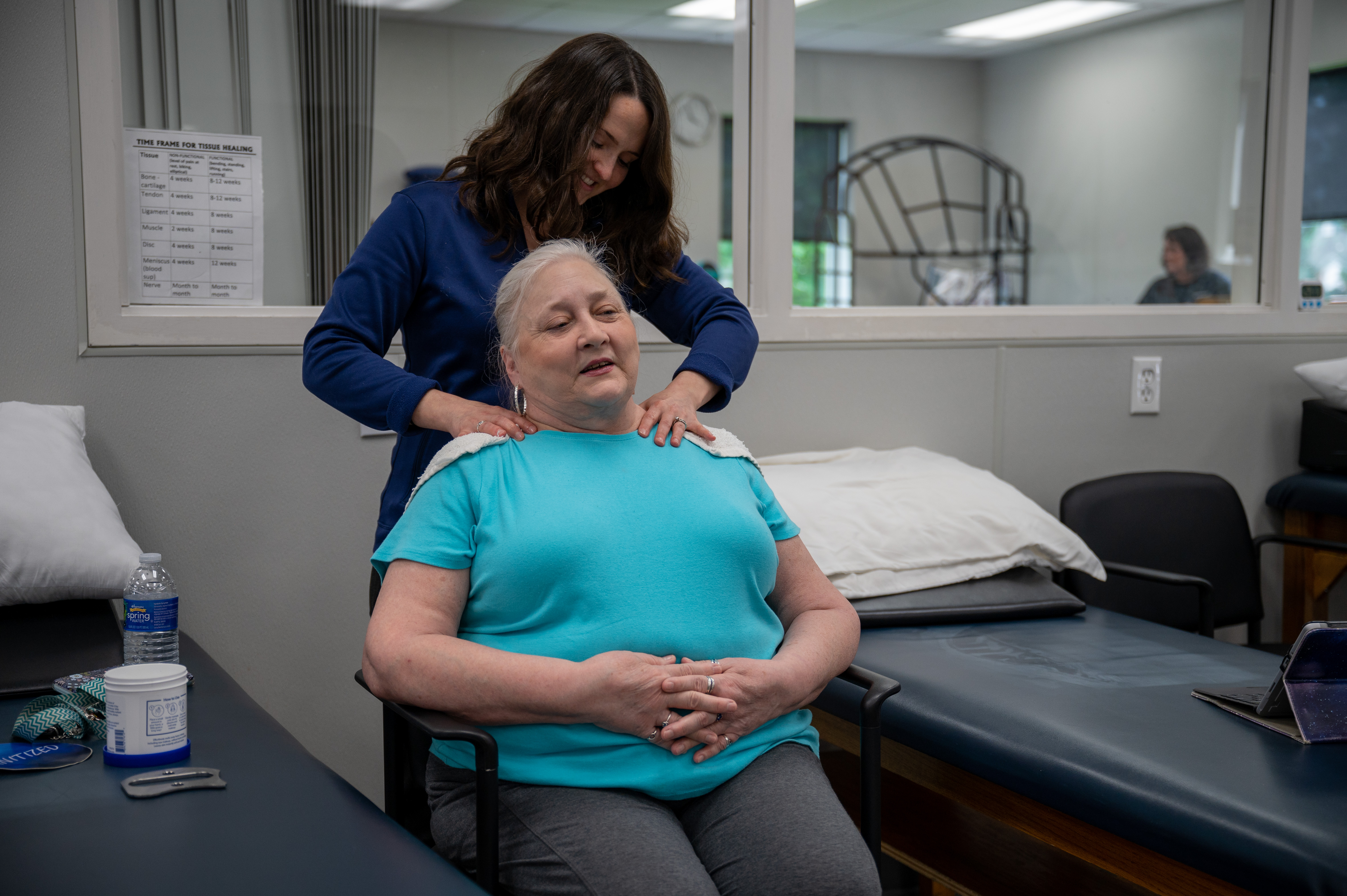 A Physical Therapist happily talking to a shoulder patient