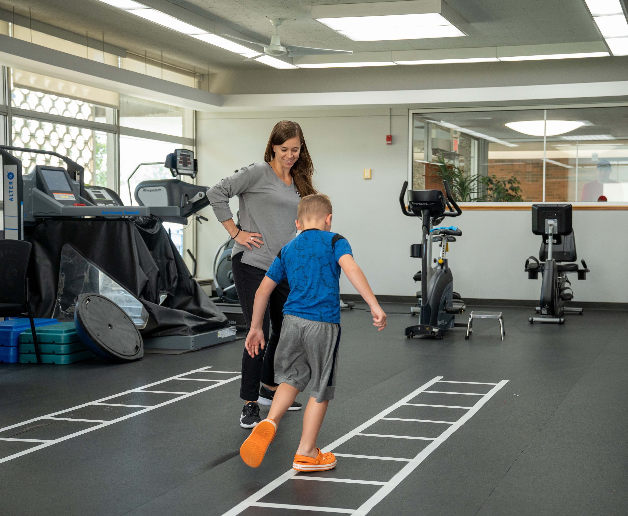 A Physical Therapist smiles at her patient.