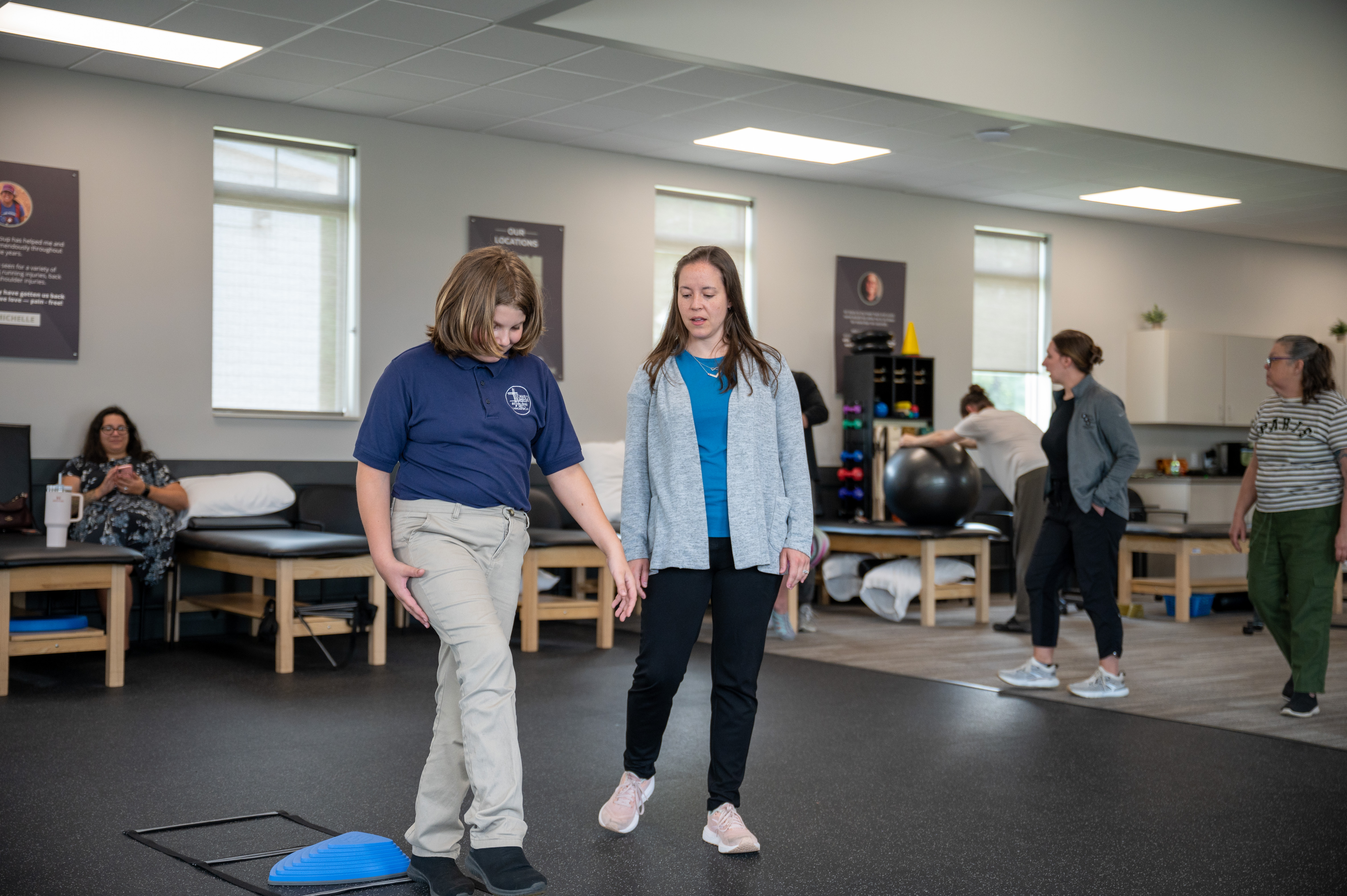 A Physical Therapist treats and injury on her patient's back, focusing intensely on the area.