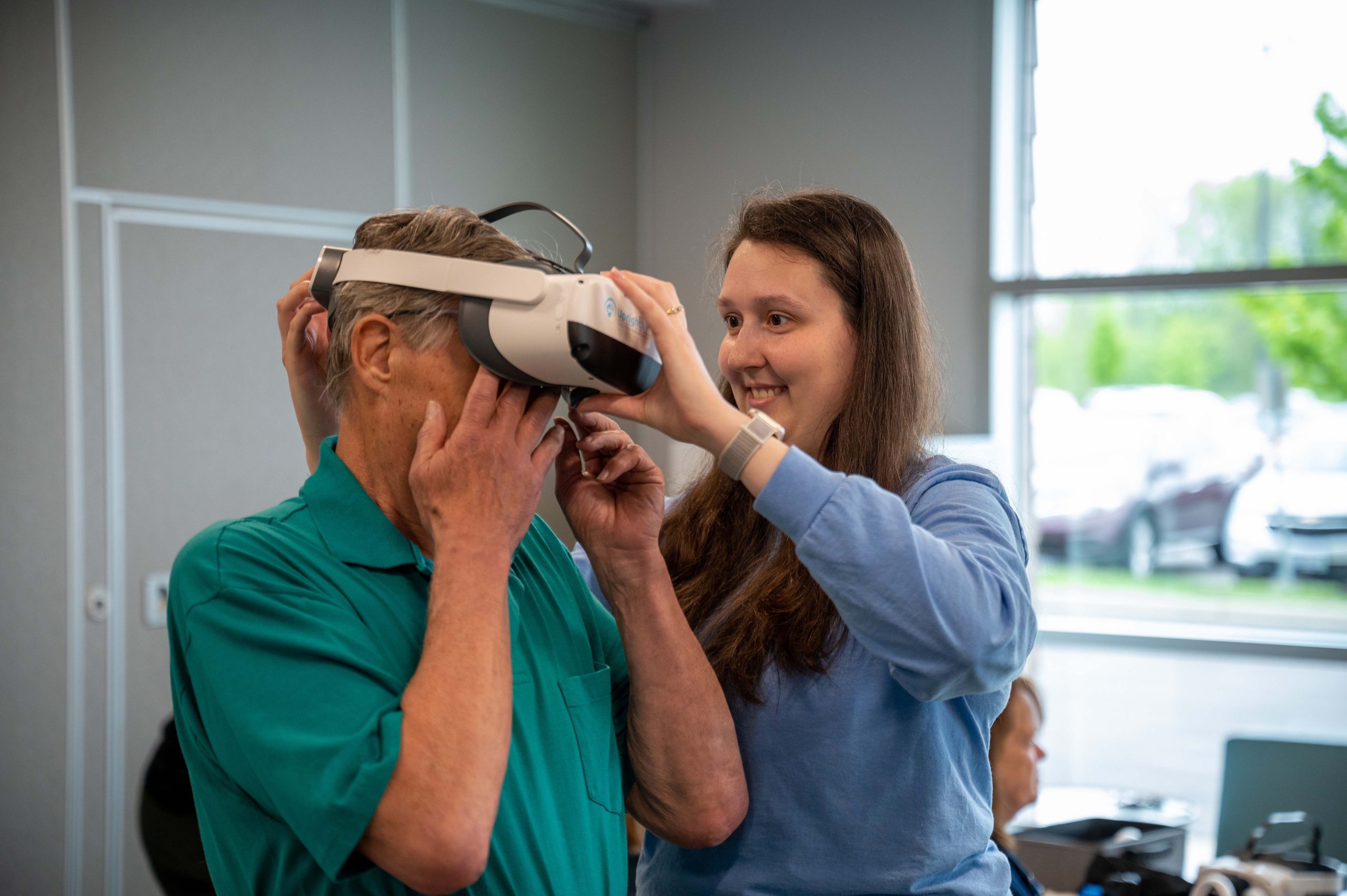 A physical therapist smiles as she converses with her patient.