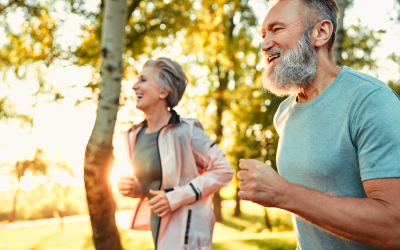 Image of a senior couple happily running together outside on a cool summer evening for exercise. Image used for the 2026 YMCA Wellness Series class, "Healthy Aging Made Simple"